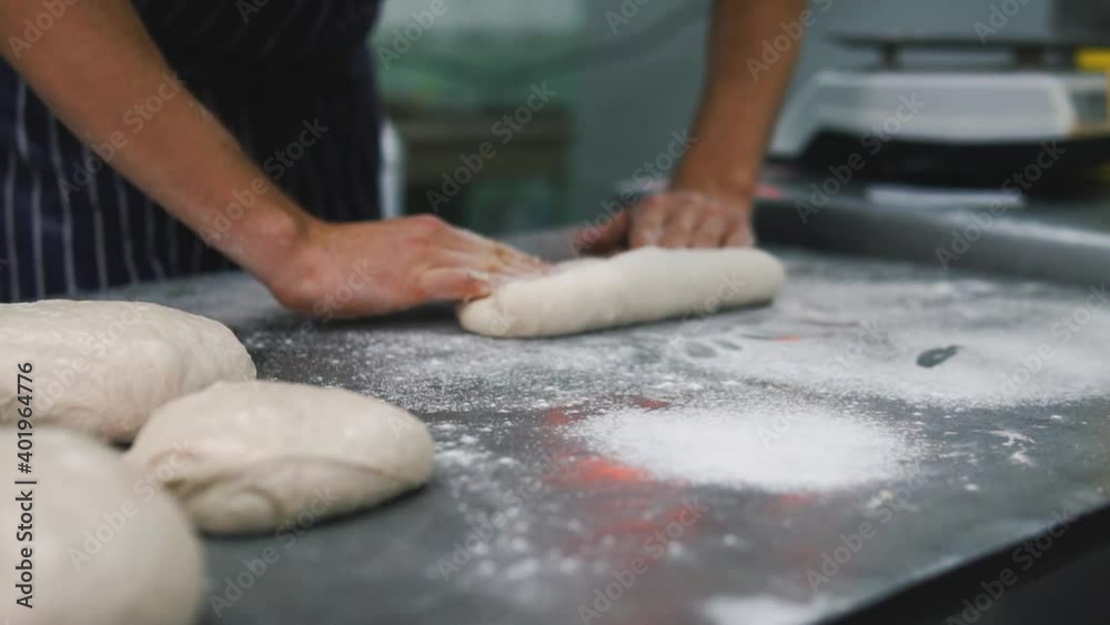 The man is kneading the dough. Hamburger buns. Bakery, production. bread, baguette, flour and water. The man is kneading the dough. Hamburger buns. Bakery, production. bread, baguette, flour and water.
