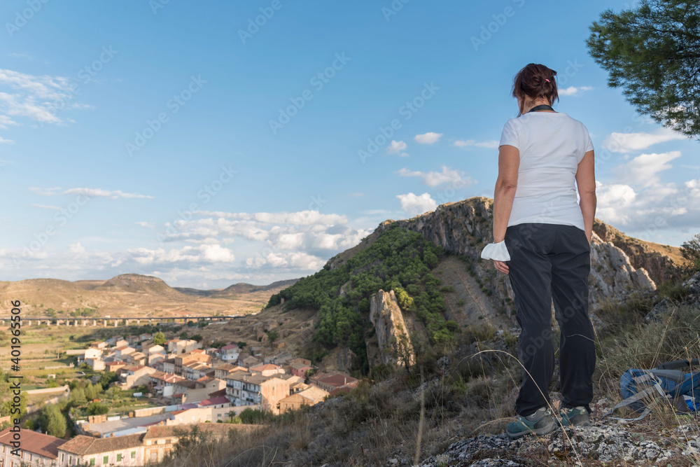 Fototapeta premium Woman looking at buildings of Alhama de Aragon in Zaragoza, Aragon, Spain, Europe