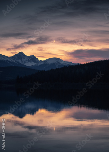 Patricia Lake with rocky mountains and the moon reflection in the sunset at Jasper national park