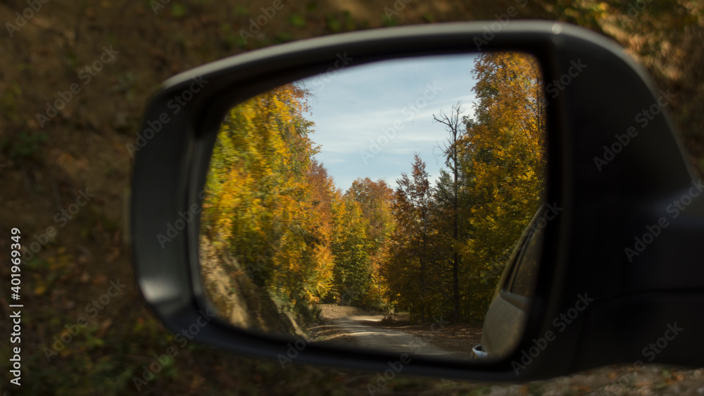 Relaxing view of the beautiful landscape reflected from the side mirror of the car. Natural beauty created by the blending of the clearly visible blue sky with green