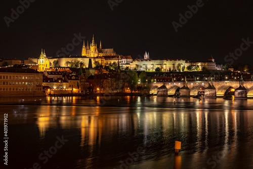 View of the city of Prague with St. Vitus Cathedral on the hill, Charles Bridge and the Vltava river at night