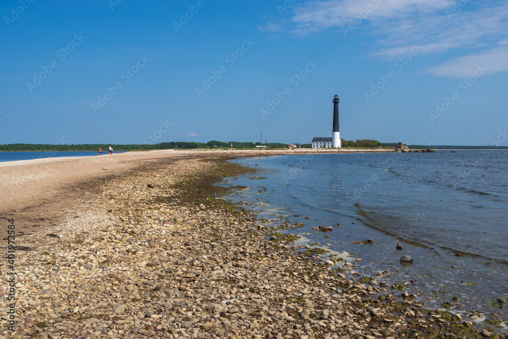 Fototapeta premium View to the beach of Sõrve peninsula cape with sand and pebbles by coastline. Lighthouse in the background. 