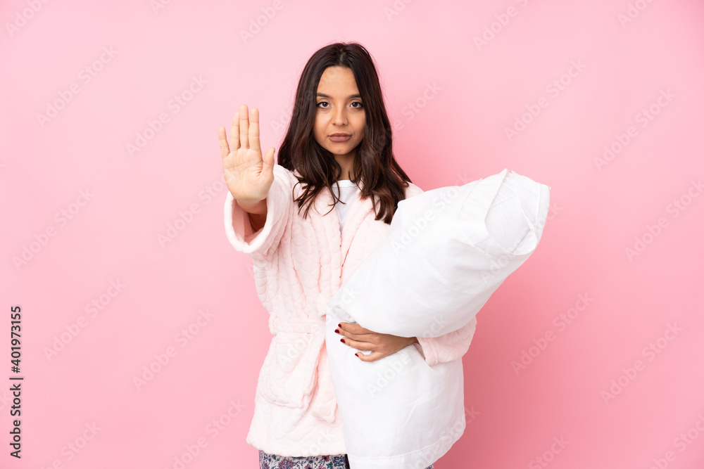 Young woman in pajamas isolated on pink background making stop gesture and disappointed Young woman in pajamas isolated on pink background making stop gesture and disappointed