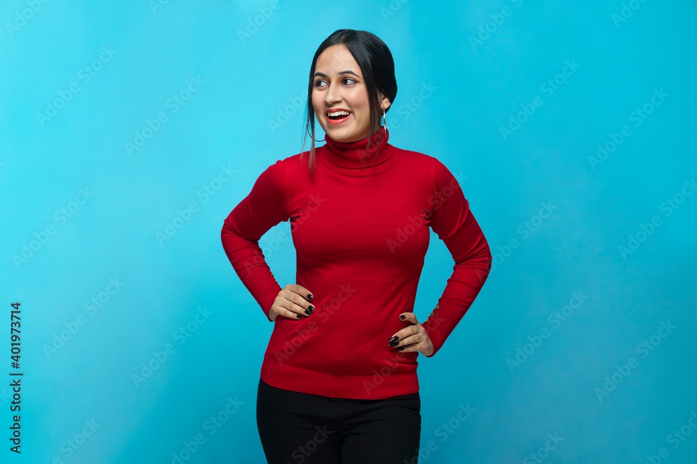 Portrait Of Young Woman With Hands On Hip Against Blue Background Portrait Of Young Woman With Hands On Hip Against Blue Background