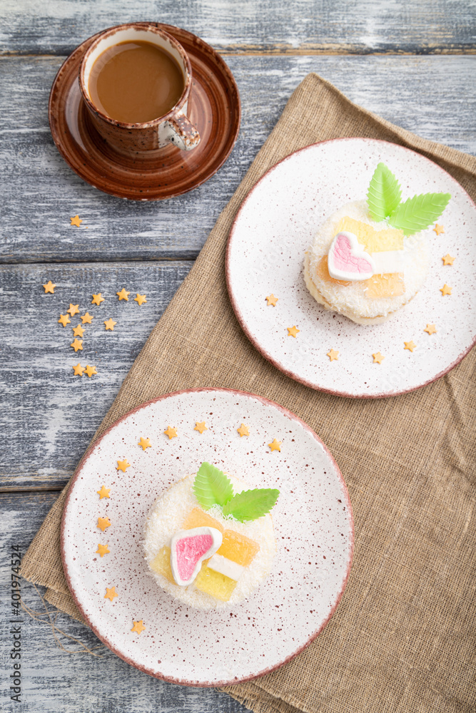 Decorated cake with milk and coconut cream with cup of coffee on a gray wooden background. top view.