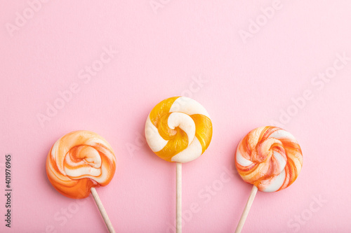 Three lollipop candies on pink background. copy space, top view