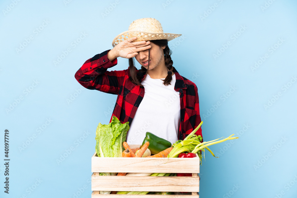Young farmer Woman holding fresh vegetables in a wooden basket with tired and sick expression