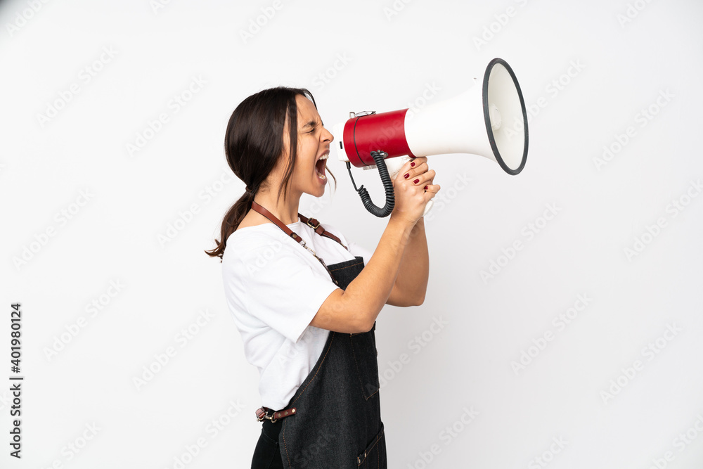 Young hairdresser woman isolated on white background shouting through a megaphone Young hairdresser woman isolated on white background shouting through a megaphone
