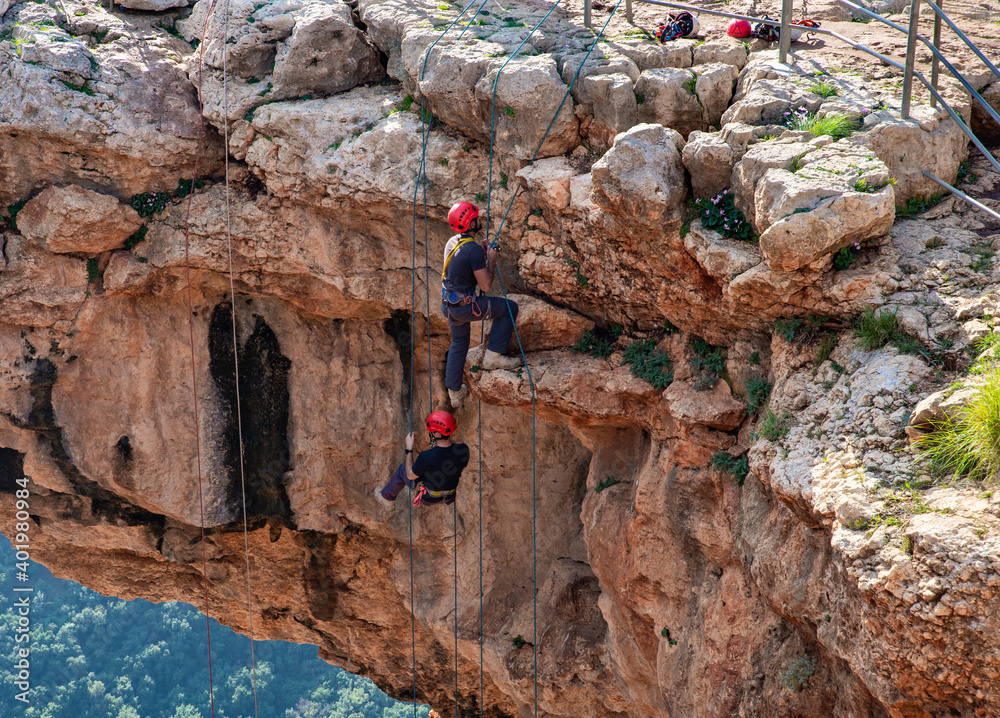Two athletes make the descent on a rope down climbing snapping