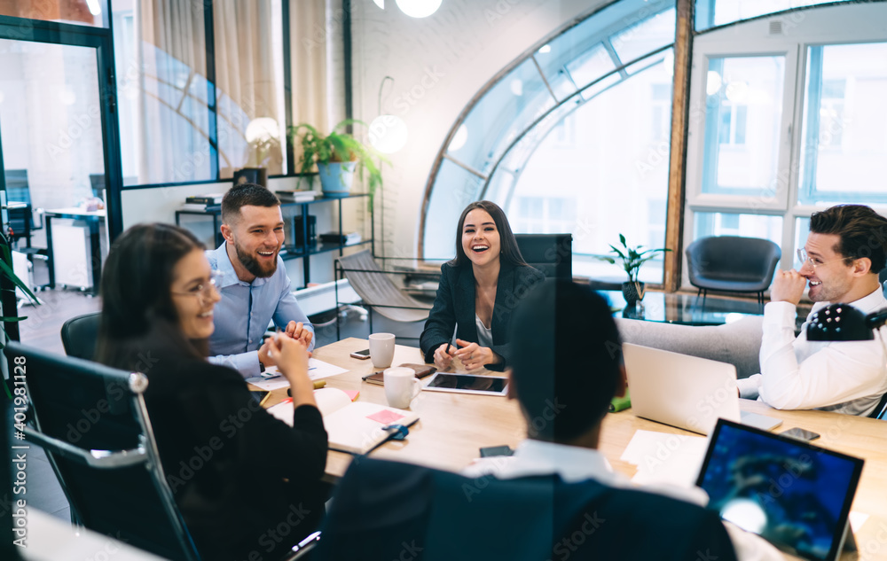 Cheerful colleagues having meeting in modern office