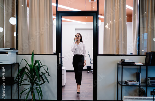 Content woman in elegant outfit entering modern office