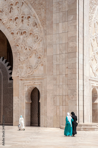 Mosque and women - Casablanca, Morocco. Traditional arabic arch and decorated ceiling of the mosque with women going to prayer.