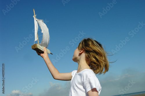 enfant avec jouet bateau en bois