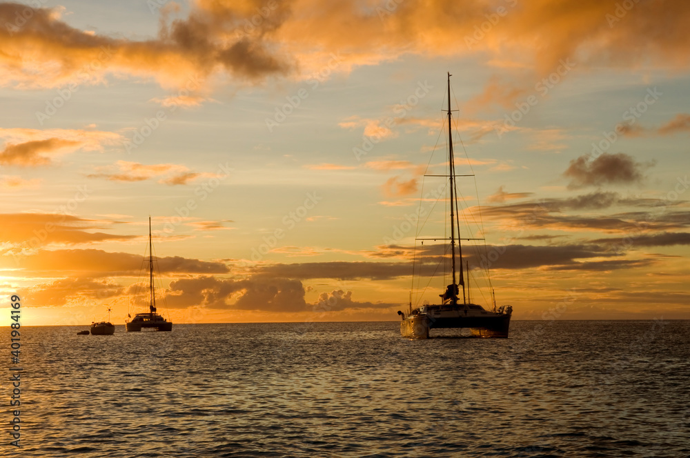Anchoring ships in tropical bay at sunset. Small yachts and catamarans on sea water during dusk. Santa Lucia. Caribbean lifestyle themes