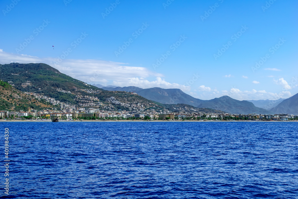 Mountain seascape with Alanya city on the coast - view from the Mediterranean Sea. Beautiful panorama of the Turkish resort town
