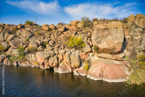 Quadro su tela A smooth shining stream flows among large boulders