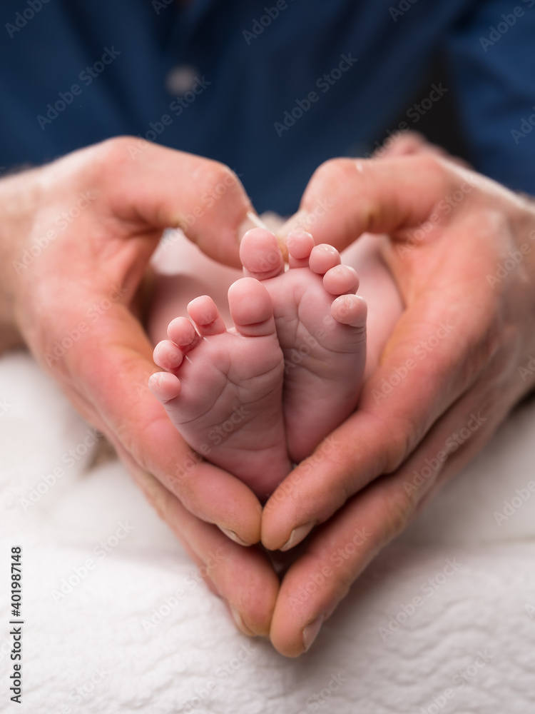 Babyfüße umrahmt von Händen in Herzform