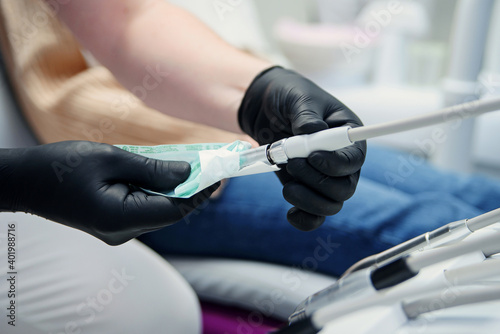 Dentist opening sealed sterile dental tools, close up. Professional dentist preparing his workplace.