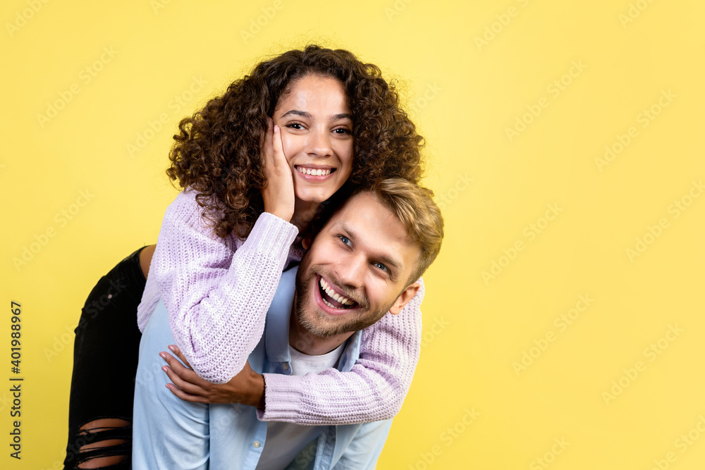 Mixed race friends standing on yellow background Mixed race friends standing on yellow background