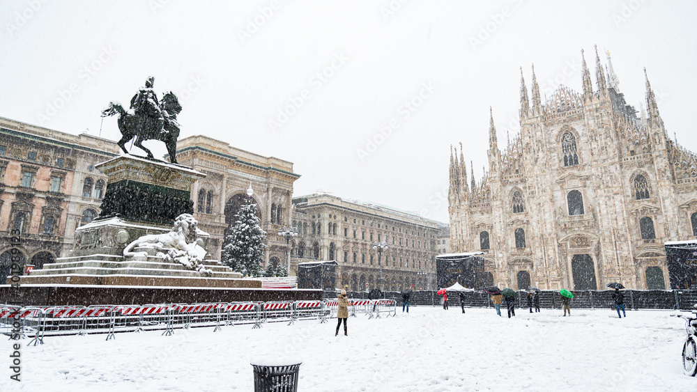 Fototapeta premium The famous statue in the middle of the cathedral square in Milan (Italy) under a heavy snowfall