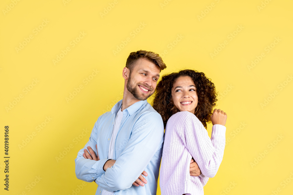 Two mixed race people standing on yellow background Two mixed race people standing on yellow background