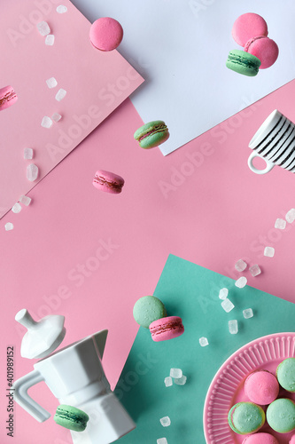 Levitation and balance composition. Flying macaroons, ceramic coffee maker and hand with espresso coffee cup. Geometric layered paper background in pastel colors, pink, cream and mint green.