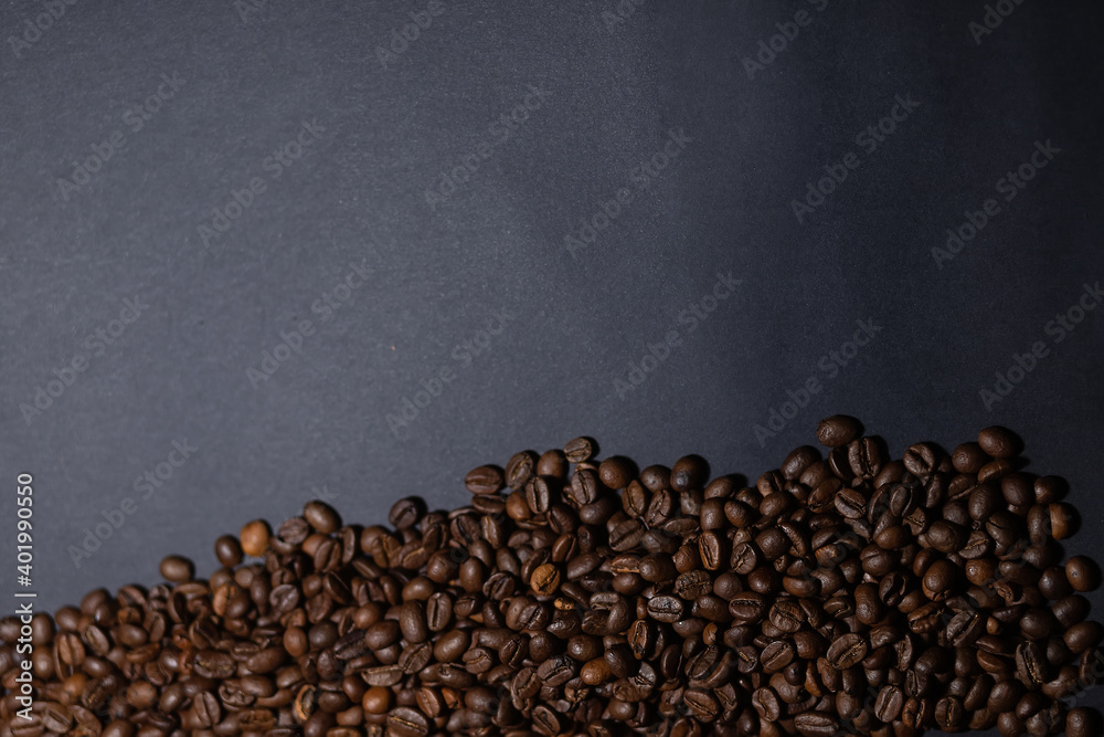heap of coffee beans on black background. Coffee beans pile isolated on black background. Culinary coffee background.