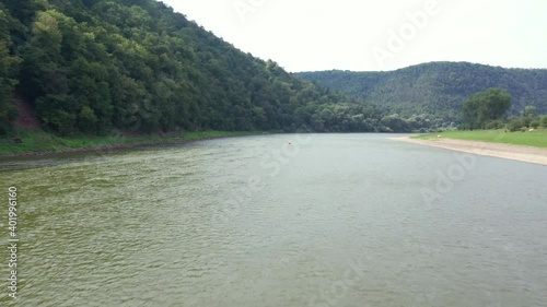 Flight through majestic river Dnestr with man on packraft orange rubber boat. Dniester canyon, Ukraine, Europe. Aerial UHD 4k drone video photo