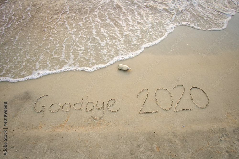 Fototapeta premium Goodbye 2020 inscription written on the sandy beach. New year conceptual.
