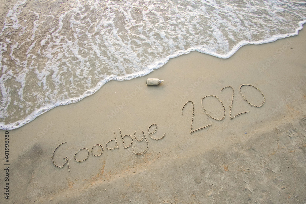 Fototapeta premium Goodbye 2020 inscription written on the sandy beach. New year conceptual.