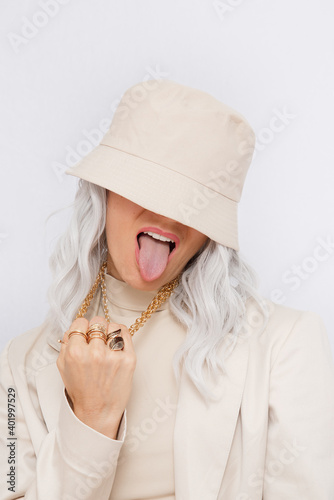 Urban street style Blonde. Details of everyday look. Casual beige outfit and accessories. Bucket hat, chain and rings. Trendy Minimalist fashion