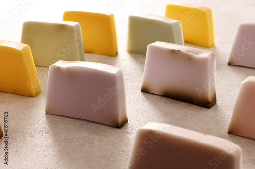 Assortment of soap bars in rows with bright light. Natural herbal colorful soaps.