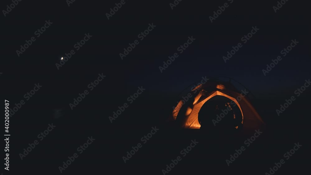 The romantic couple sitting at the night campsite tent The romantic couple sitting at the night campsite tent