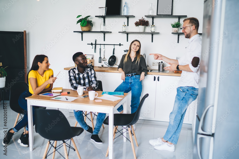 Positive diverse coworkers chatting about project Positive diverse coworkers chatting about project