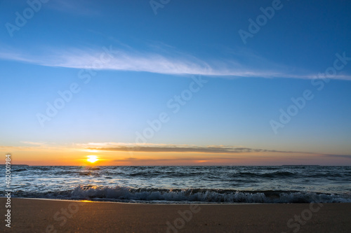 Sunset over the sea. Reflection of sunlight in the sea waves. The sky in the sunset rays. Baltic Sea.