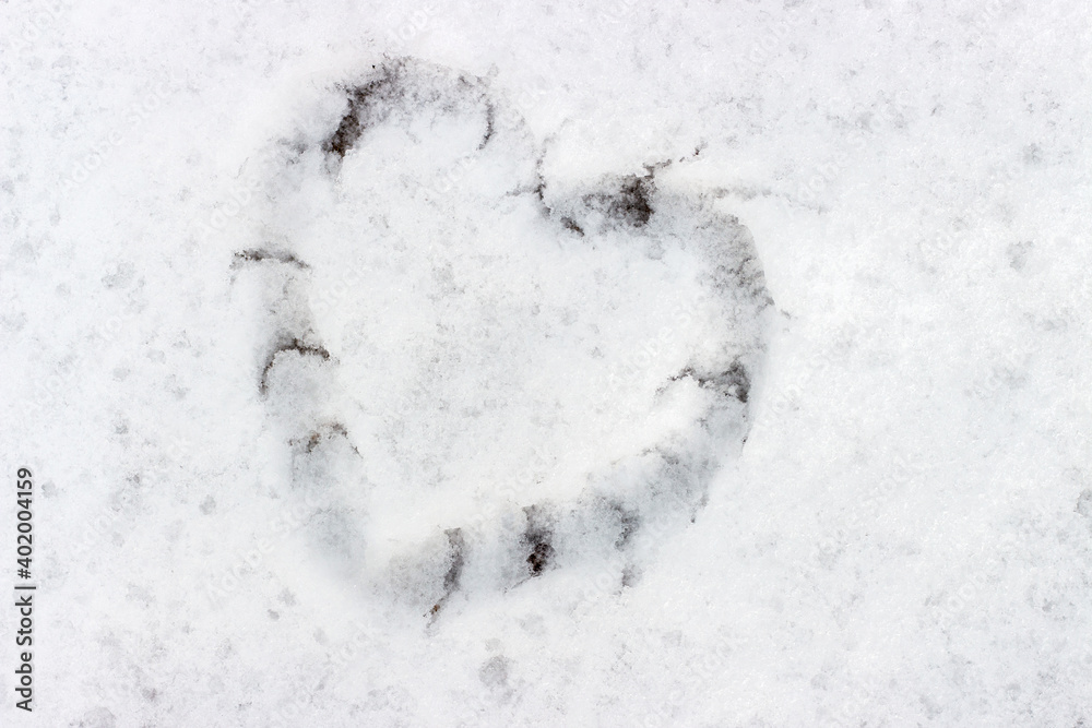 Heart shape drawn on snow close-up, winter background Heart shape drawn on snow close-up, winter background