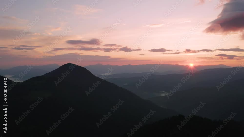 A magical sunrise in the foggy summer Carpathian mountains from a flying drone. Pink rising sun and dark ridges in the background. UHD 4k video A magical sunrise in the foggy summer Carpathian mountains from a flying drone. Pink rising sun and dark ridges in the background. UHD 4k video