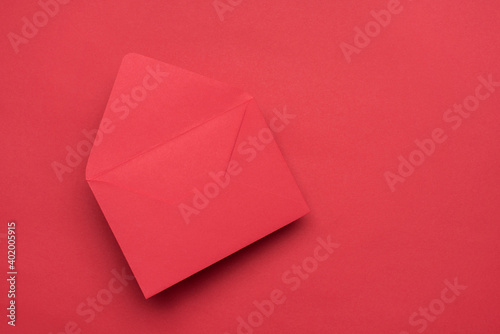 Photo of open empty red monochromatic flying with shadow envelope isolated bright color background