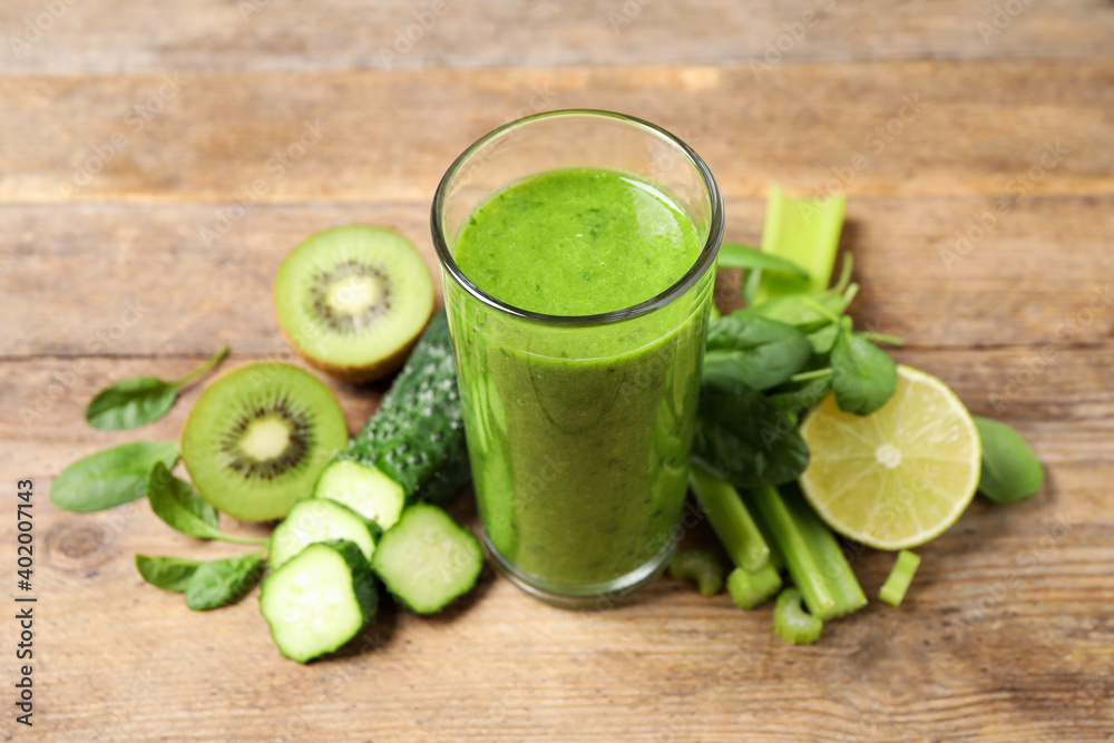 Delicious green juice and fresh ingredients on wooden table Delicious green juice and fresh ingredients on wooden table