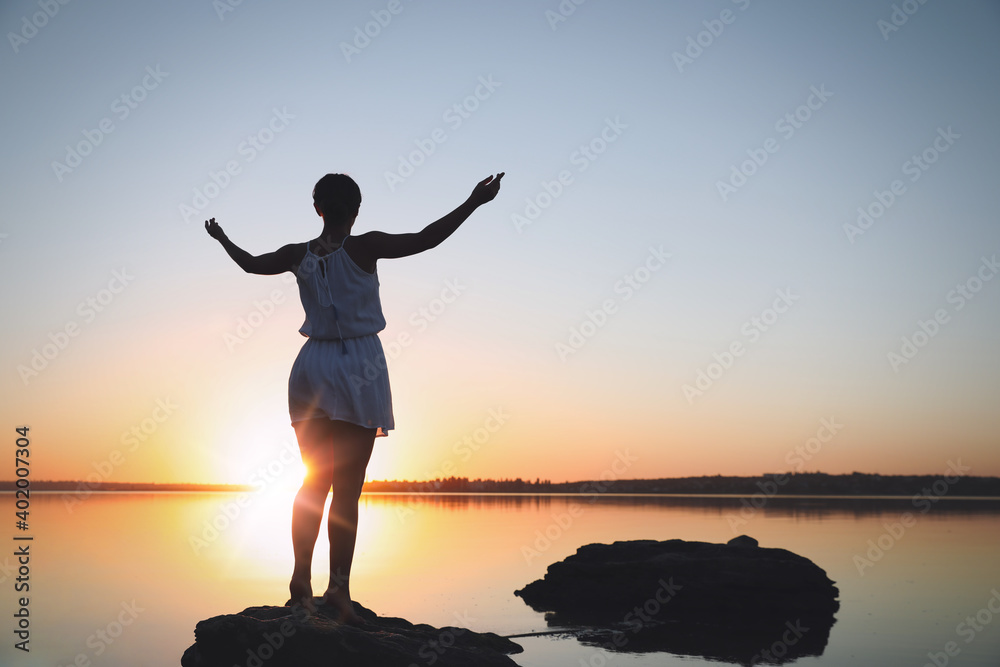 Fototapeta premium Woman near river on sunset. Healing concept