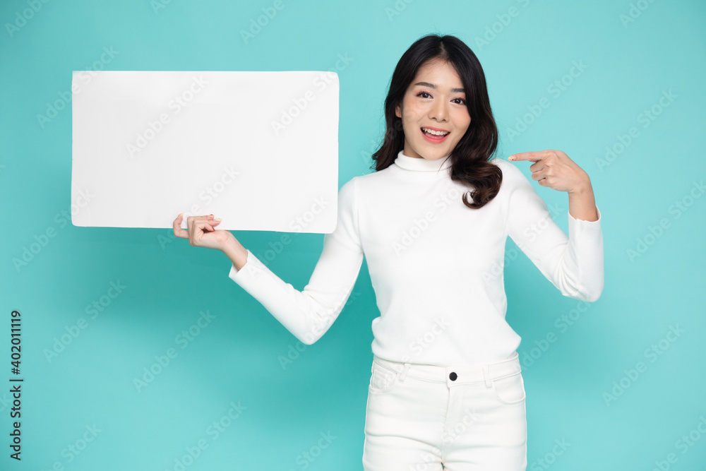 Young asian woman showing and holding blank white billboard isolated on green background Young asian woman showing and holding blank white billboard isolated on green background