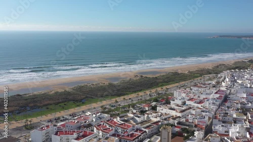 Beaches of the Atlantic ocean in Andalusia next to Conil de la Frontera seen from above. Aerial footage of white town in South Spain at the Atlantic Ocean