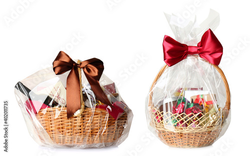 Wicker baskets full of different gifts on white background photo