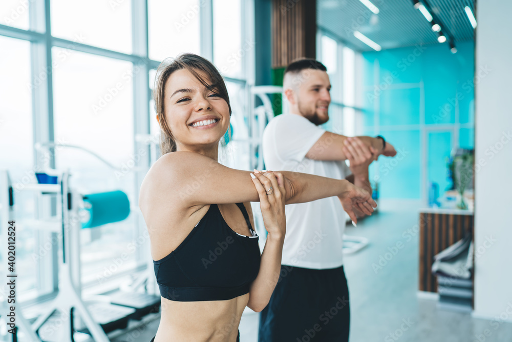 Happy smiling couple warming up in gym Happy smiling couple warming up in gym