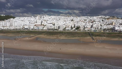 Los Bateles beach with paseo maritimo in winter seen from above aerial view of white coast town in Andalusia at the Atlantic Ocean