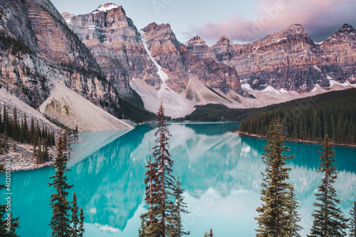 The beautiful deep blue waters and reflections of Moraine Lake at sunrise. Moraine Lake is located in Banff National Park in Alberta, Canada, situated in the Valley of Ten Peaks.