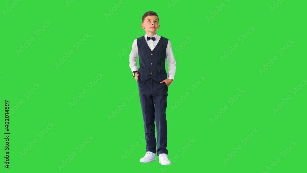 Schoolboy in waistcoat and bow tie checking his watch, rolling eyes and sighing on a Green Screen, Chroma Key. Schoolboy in waistcoat and bow tie checking his watch, rolling eyes and sighing on a Green Screen, Chroma Key.