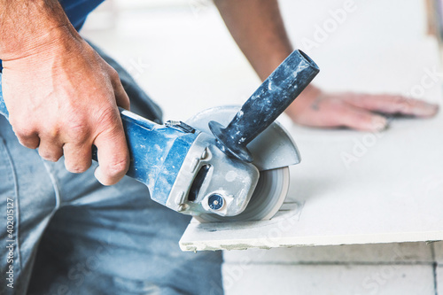 Industrial tiler builder worker working with floor tile cutting equipmen
