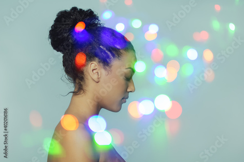 Double exposure portrait of young beautiful african american woman and bokeh lights, modern art