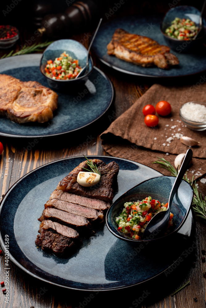 Assortment of juicy appetizing steaks on a wooden table of a fancy restaurant
